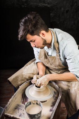 Potter, atölye, Seramik Sanat kavramı - closeup çalışma potters ham kil ile tekerlek ve eller mans, genç esmer erkek heykel bir kap ile parmak, içinde ana önlüklü, Meksika, İspanyol