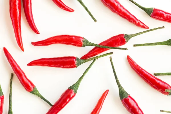 red hot chili peppers, popular spices concept - closeup on beautiful red hot chili peppers isolated on white background, green tails, collage of freely lying peppers, top view, flat lay.