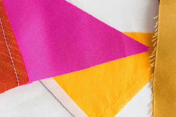 绗缝、 缝纫、 裁剪、 时尚的概念 — — 美丽的彩色拼布面料，红色，黄色，紫色缝合的纺织废料在研讨会上，平躺，顶视图. — 图库照片