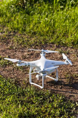 quadcopter açık havada, havadan görüntüleri ve hobi, eğlence kavramı - quadrocopter kalkış, beyaz e-gözlemci için hazır ile dört pervane ve yaz çimen, dikey ile kalkıştan önce dijital fotoğraf makinesi.