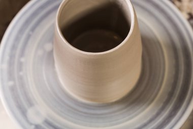 çanak çömlek, atölye, Seramik Sanat kavramı - yakın çekim bir çiğ kil Kupası ayakta potters tekerlek, yapılan yeni bazı gereçler ürün üzerinde üzerinde ham şamot ve insan eli tarafından Sudan, görünümü top.