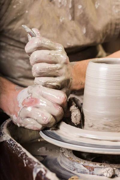 Cerâmica, oficina, conceito de arte cerâmica macho mestre esculpir um utensílio com esponja e ferramentas de escultura, homem mãos trabalhar com roda oleiros, dedos forma de argila crua, vertical . — Fotografia de Stock