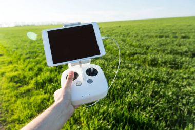 quadcopter uçuşlar açık havada, havadan görüntüleri ve teknoloji hobi, eğlence kavramı - beyaz dron uzaktan kumanda uçuş görünümü, zemin üzerine yeşil çim alan için yüklü tablet Pc ile işletmeninde bulunur.