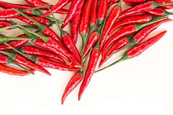 red hot chili peppers, popular spices concept - beautiful handful of red hot pepper in bulk, pods scattered on white background, top view, flat lay, free space for your text.