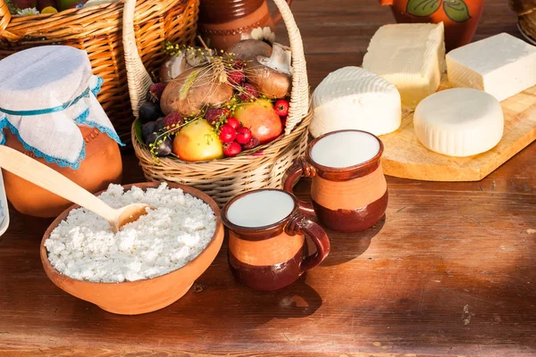 Mejeriprodukter på träbord. Ost och mjölk på bordet i en lergods maträtt. Landsbygdens mat. Mat bakgrund. — Stockfoto