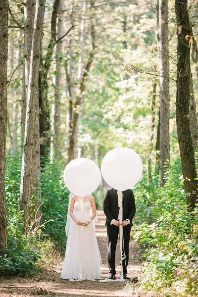 Sposi con palloncini bianchi. la fotografia divertente con persone appena sposate . — Foto Stock