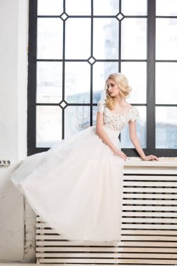 moda gelinlik, güzel sarışın model, gelin saç ve makyaj kavramı - glamour kapalı pencerenin, stüdyoda poz çok kadın önünde beyaz elbiseli genç kadın.