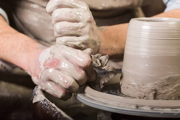 Tembikar, lokakarya, konsep seni keramik tangan laki-laki bekerja dengan roda tembikar, jari-jari bentuk tanah liat mentah, master laki-laki memahat perkakas dengan alat ukir, tampilan depan . — Stok Foto