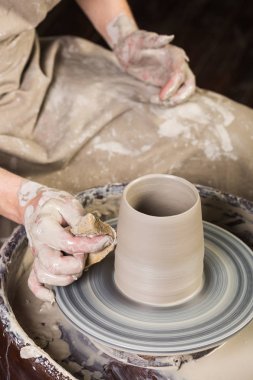 çanak çömlek, atölye, Seramik Sanat kavramı - potters tekerlek ve ham şamot, adam çalışır yong erkek heykeltraşlık eller, aracı, parmak ve su, üstten görünüm, dikey ile yeni mutfak eşyaları.