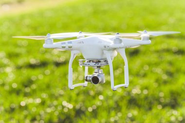 Rusya, Rostov-On-Don-20 Nisan 2017: quadrocopter kalkış, düşük üzerinde beyaz drone ile kurmak-içinde fotoğraf makinesi arka planını yaz çim sahası, closeup Önden Görünüm, uçan.