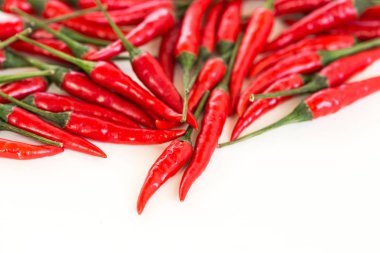 Red hot chili peppers, popüler baharatlar kavramı - kırmızı acı biber toplu, olgun taze bakla ile yeşil peduncle beyaz zemin üzerine düz dağınık olarak avuç yatıyordu, metniniz için boş alan güzel.