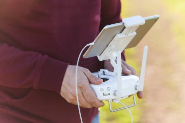 quadcopter uçuş açık havada, havadan görüntüleri ve teknoloji hobi, eğlence kavramı - robot operatör el uzaktan kumanda uçuş ve tablet Pc ekran çekim video görsel gözlem altında tutmak.
