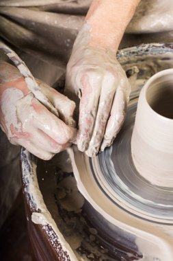 çanak çömlek, atölye, Seramik Sanat kavramı - potters tekerlek ile çalışan erkek elleri parmakları ham kil şeklindebir, erkek ana heykel oyma aracı, üstten görünüm, dikey ile bir kap.