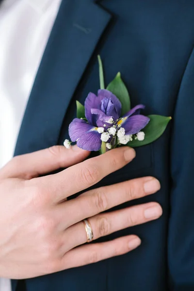 Knoopsgat van verse bloemen van een iris op een blauwe jas van de bruidegom close-up. — Stockfoto
