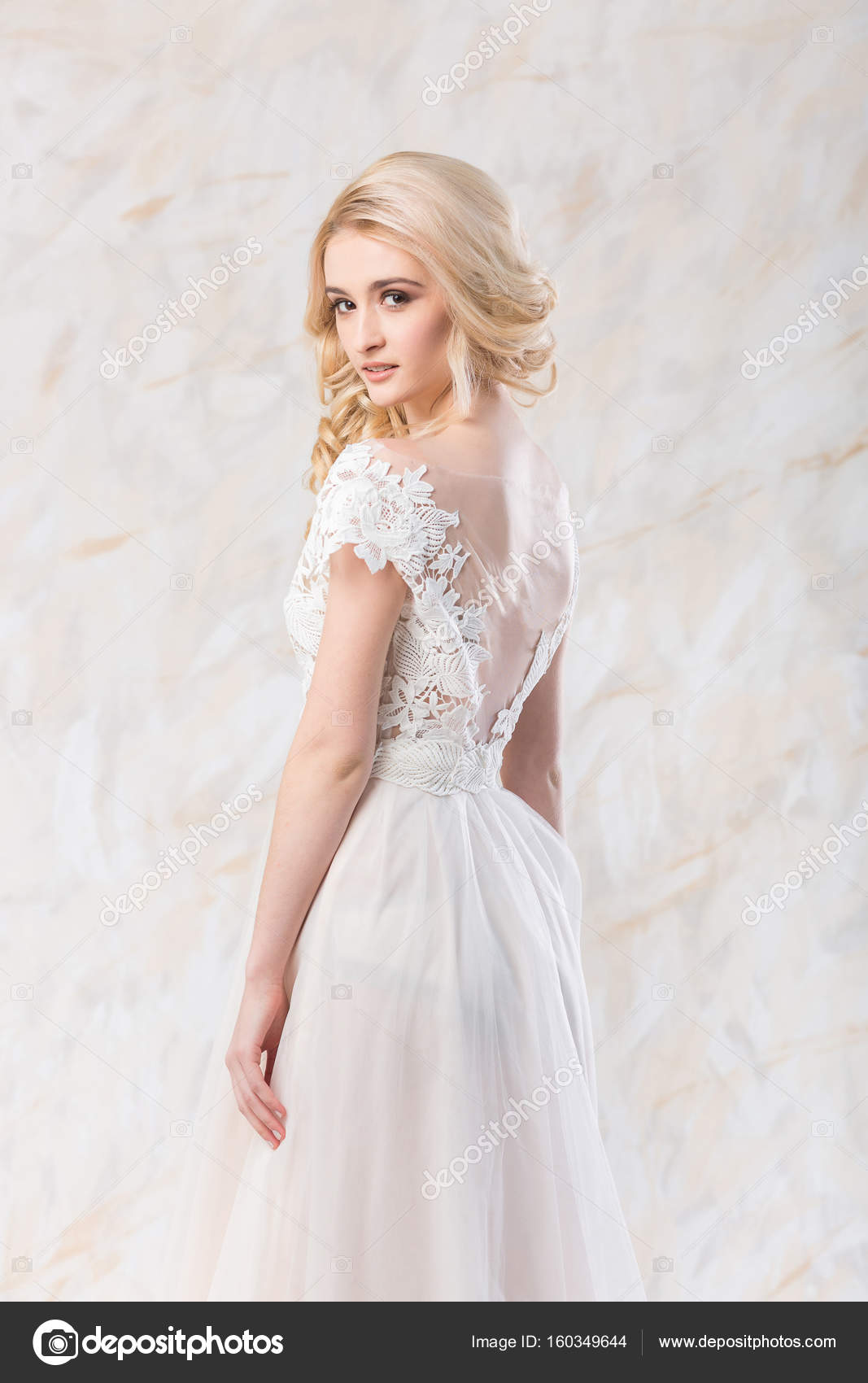 Gorgeous bride in white gown with stylish hairstyle and veil Stock Photo by  Sonyachny