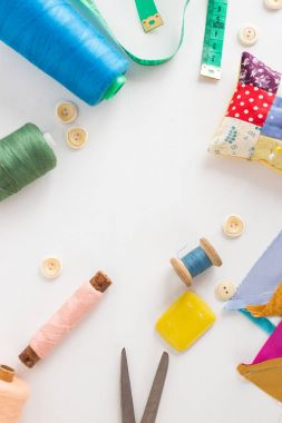 lay düz dikiş araçları, patchwork, terzilik ve moda kavramı - closeup beyaz Danışma, renkli iplik biriktiricileri, ölçme metre, düğmeleri, makas, iğne yastığı, iğne işi, dikey, için donatım.