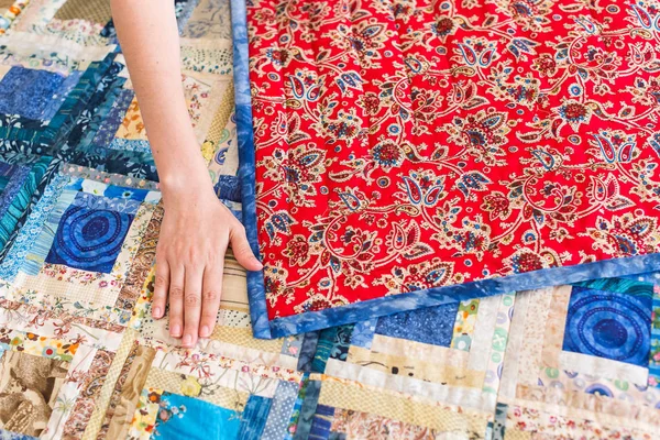 Traditions, passe-temps, concept de menuiserie. vieille couverture artisanale avec motif traditionnel russe de khokhloma cousu sur textile satiné rouge avec fil d'or — Photo