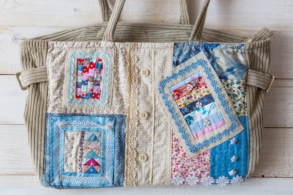 hobi, sanat, moda kavramı. kadınsı kadife el çantası sıcak renkler satine dekore edilmiş Tekstil satine Tekstil, düğmeler ve gökyüzü ve bulutlar kare uygulamalarla kılıflı