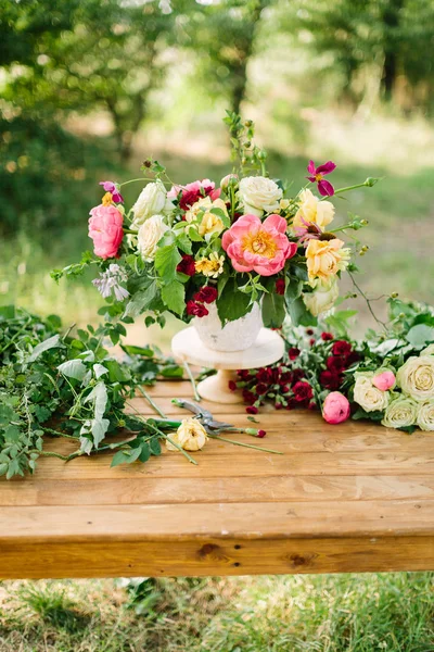 Bouquet, holiday flower, gift and floral arrangement concept - wonderful bouquet in white vase on wooden table at green garden, white and yellow roses, pink peonies, red carnations, vertical. — Stock Photo, Image