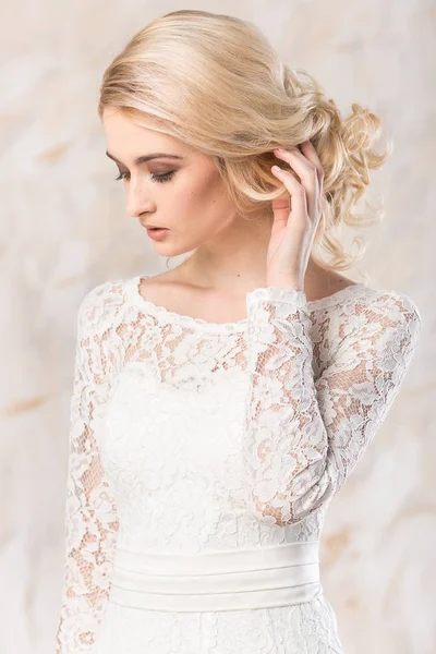 Vestido blanco de moda, hermosa modelo rubia, peinado de novia y el concepto de maquillaje - primer plano joven romántica dama en vestido de fiesta de boda de pie en el interior sobre fondo claro, mujer bonita posando . — Foto de Stock