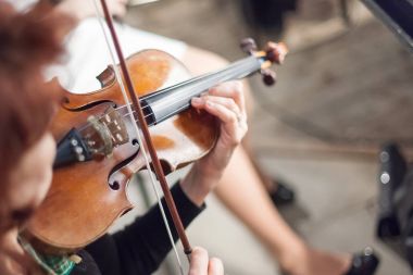 performans, müzik, orkestra kavramı. en zarif müzik aleti, keman, müzisyen ihale elinde. have dört teli ve güzel genç kadın şeklinde