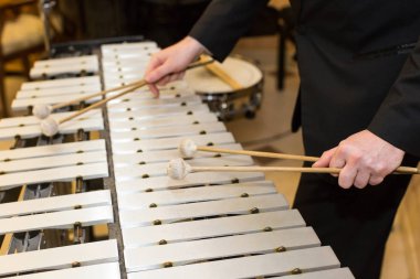 ksilofon, vurmalı enstrüman kavramı - closeup insan elinde dört Tokmaklar, siyah elbise, glockenspiel, Orkestrası konser, müzik, seçici odak sanat sanatçı ile ahşap çubukları hakkında.
