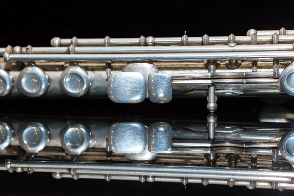 Concepto de música sinfónica - primer plano de flauta de concierto occidental se encuentra en la superficie del espejo negro puro, sección del cuerpo medio del instrumento con la mayoría de las teclas, marcha, conciertos de orquesta, macro . — Foto de Stock