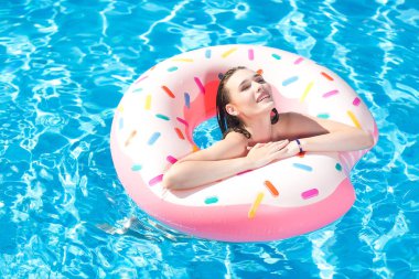 Genç beyaz beyaz güzel kadın rahatlatıcı yüzme havuzunda. Gülen ve having fun aquapark kauçuk halka ile Yüzme seksi kız. Yaz tatili ve aktif tatil kavramı.