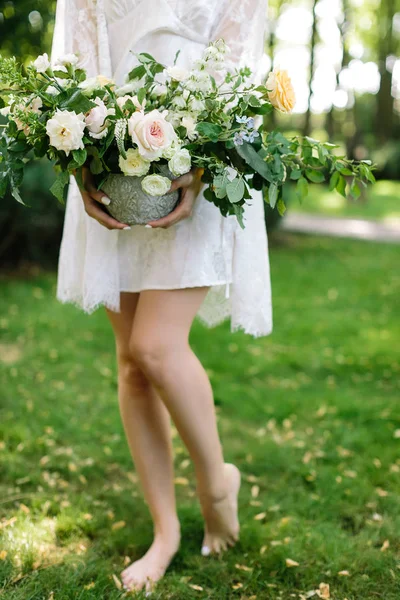 Beleza, aparência, conceito de natureza. encantadora criatura sylphelike com longas pernas finas vestindo vestido branco com manto de renda segurando vaso com grande buquê lindo de flores — Fotografia de Stock