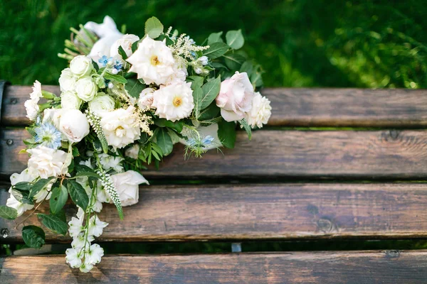 Ehe, Liebe, Empfindungskonzept. Auf der hölzernen Gartenbank in Schokoladenfarbe liegen Blumen im Brautstrauß. mit negativem Raum für Text — Stockfoto