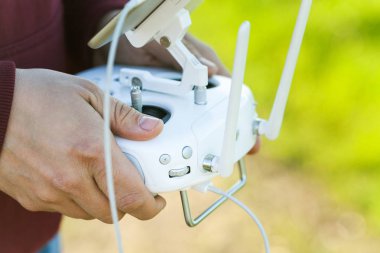 quadcopter uçuş açık havada, havadan görüntüleri ve teknoloji hobi, eğlence kavramı - closeup pilot eller ve beyaz uzaktan radyo kontrol, uçan ve kalite filme sevinç için modern teknoloji çözüm.