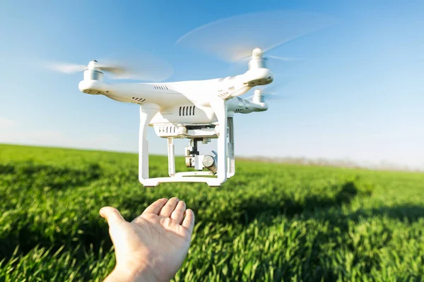 Rusya, Rostov-On-Don-20 Nisan 2017: Erkek el, mavi gökyüzü arka plan ve yeşil çim alan yakınındaki alçak irtifada uçan closeup modern beyaz yüksek teknoloji helikopter.