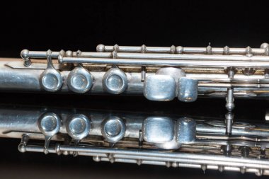 senfonik müzik ve bando kavramı - Batı konser flüt güzel closeup yatıyor saf siyah ayna yüzey, askeri, yürüyen, orkestra, topluluklar, caz konseri enstrüman kullanımı.