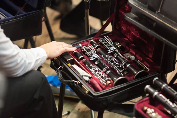 Música, performance, conceito de equipamento. braço do jogador tocando ternamente desmontado clarinete preto fosco, mantido em pequena caixa especial com forro de veludo lindo de bela cor borgonha — Fotografia de Stock