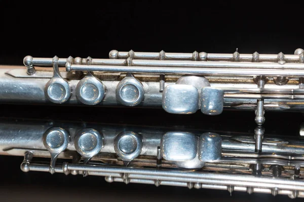 senfonik müzik ve bando kavramı - Batı konser flüt güzel closeup yatıyor saf siyah ayna yüzey, askeri, yürüyen, orkestra, topluluklar, caz konseri enstrüman kullanımı.