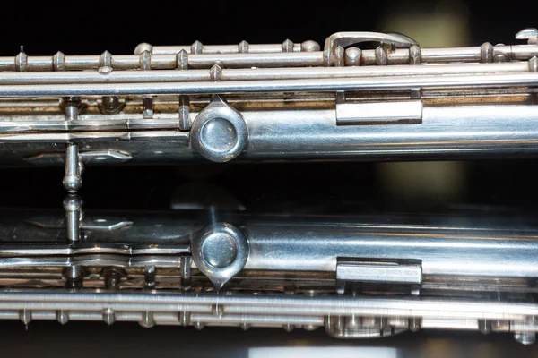 Concepto de música sinfónica - primer plano del cuerpo de la flauta de concierto occidental se encuentra en la superficie pura espejo blanco y negro, sección media del instrumento de viento, estudio y uso de conciertos de orquesta, macro . — Foto de Stock