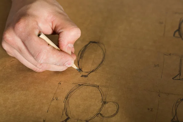 Fabrication de poterie, outils artisanaux, concept d'art céramique - gros plan sur la main des jeunes hommes et dessin au crayon de travail de la faïence, a planifié la conception et les tailles des produits futurs, vue de dessus . — Photo