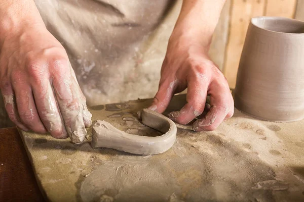 Pembuat tembikar, tukang batu, konsep seni keramik jari-jari pengrajin membentuk pegangan dari petasan mentah, tangan master bekerja dengan beberapa bagian dari tanah liat, berdiri laki-laki di sebuah bengkel di dekat meja . — Stok Foto