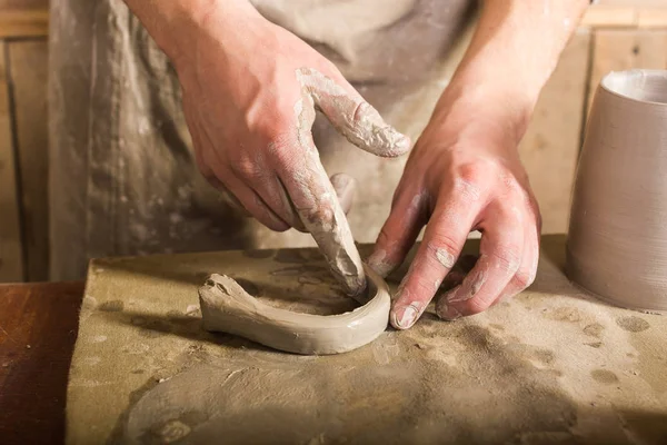 陶器、 石器、 陶瓷艺术概念-特写工匠手指形成从原料粘土，主手工作与一些片的粘土，男性站在桌子旁边的车间控制柄上. — 图库照片