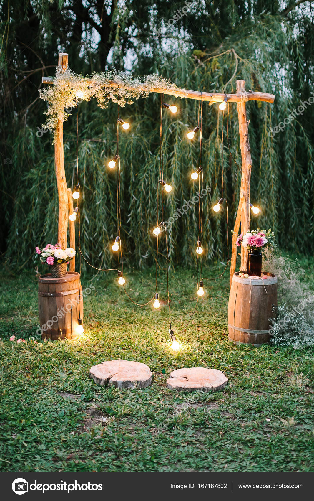 Ceremonia de compromiso, amor, concepto de diseño. en el crepúsculo hay  impresionante arco de boda decorado en estilo rústico con luces  centelleantes y ramos de flores diversas — Foto de stock #167187802 ©, image size:1067x1700