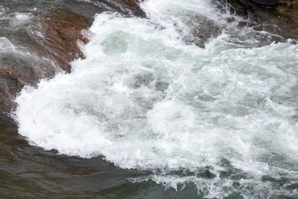 Vodní zdroje, rafting, cestování koncept. surové vody řeky vytváří podmořské víry v nebezpečné fáze peřejí s pomocí velkých kamenů a nerovný povrch — Stock fotografie