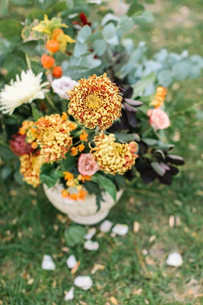 Χλωριδική, γαμήλια, κόμμα διακόσμηση έννοια. κοντινό πλάνο του φωτεινό ηλιόλουστο πορτοκαλί chrisantemums που συνδυάζονται πολύ καλά με λεπτή ροζ τριαντάφυλλα και τα φύλλα των διαφόρων φυτών — Φωτογραφία Αρχείου