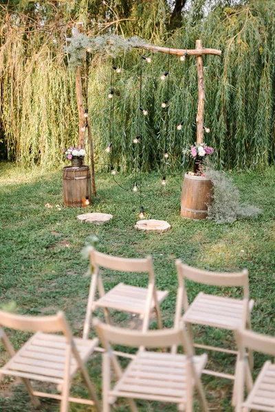 浪漫, 订婚, 庆祝的概念。装饰婚礼在生态风格与木材和花卉的元素, 改善与照明, 放置在农村 — 图库照片