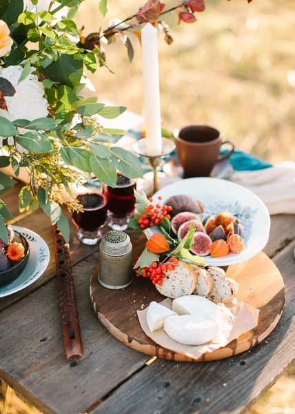 tazelik, piknik, tatil kavramı. açık havada taze ekmek ve peynir, meyve ve köpüklü şarap ile romantik bir akşam yemeği gözlük, yakın var gıda ile tahta flüt