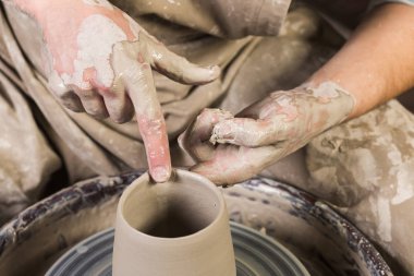 çanak çömlek, atölye, Seramik Sanat kavramı - portre üzerinde mans çömlekçi çarkı ve ham kil elleri çalışmak, erkek parmak heykeltraşlık su, üstten görünüm ile bazı yeni mutfak eşyaları.