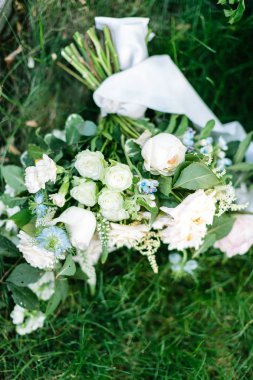 kutlama. evlilik, Bahar kavramı. taze yeşil çim işte zarif güller ve muhteşem karanfil geleneksel beyaz renkte oluşan gelin buketi