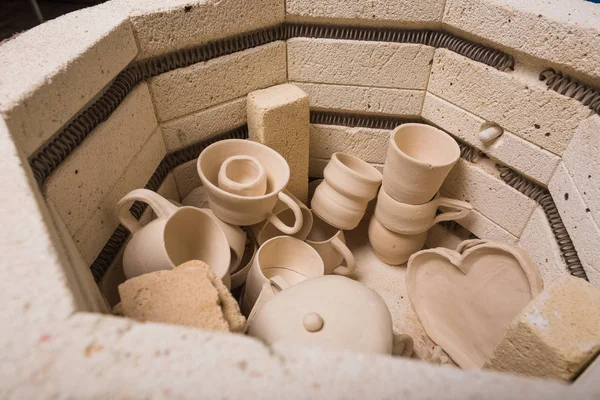 Cerâmica, oficina, conceito de arte cerâmica vista superior do forno elétrico para posterior torrefação de produtos de argila inacabada, forno para copos e jarros não cozidos, perto . — Fotografia de Stock