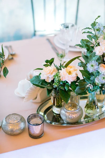 Design, style de vie, concept romantique. sur la vaisselle pêche il ya beaucoup de différentes petites grappes de roses et d'autres fleurs placées sur le plateau d'argent à proximité avec des bougeoirs d'origine — Photo