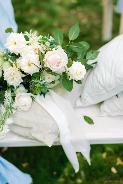 Verlobungszeremonie, Feiertage, Gesteckkonzept. es gibt einen Hochzeitsstrauß, der vom Floristen mit verschiedenen Arten von Rosen gemacht und mit Grün und schillernder weißer Schleife dekoriert wurde — Stockfoto
