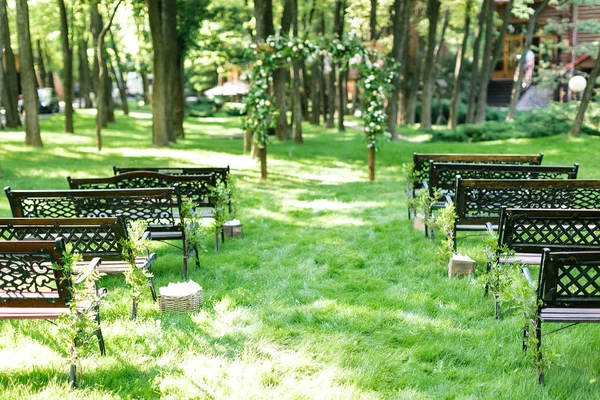 Nişan, çevre, peyzaj tasarım konsepti. koyu kahverengi arasında yeşil geçit yolu güzel yol ahşap Bahçe Banklar evlilik töreni için kemer.